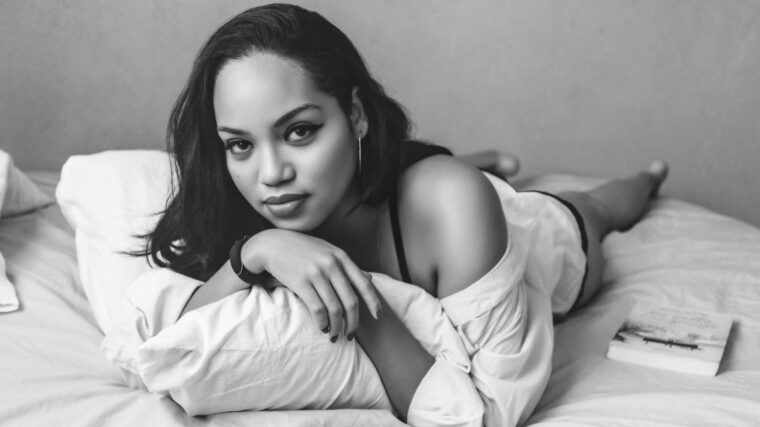 a black and white photo of a woman laying on a bed