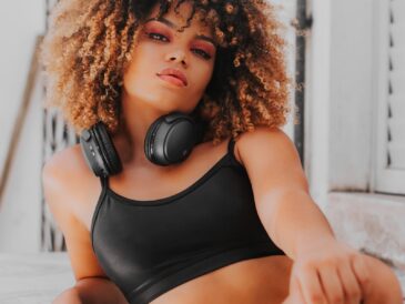 a woman wearing headphones sitting on a ledge