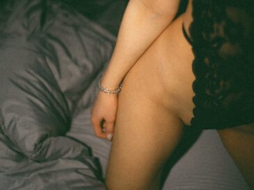 a naked woman sitting on top of a bed