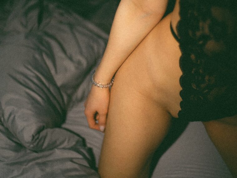 a naked woman sitting on top of a bed